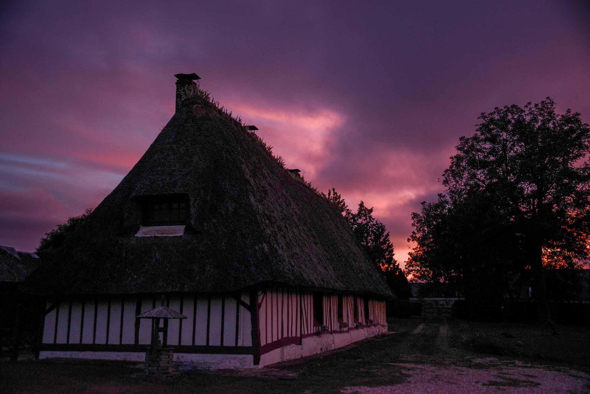 Chaumière normande au toit de chaume dans la vallée de la Seine au crépuscule
