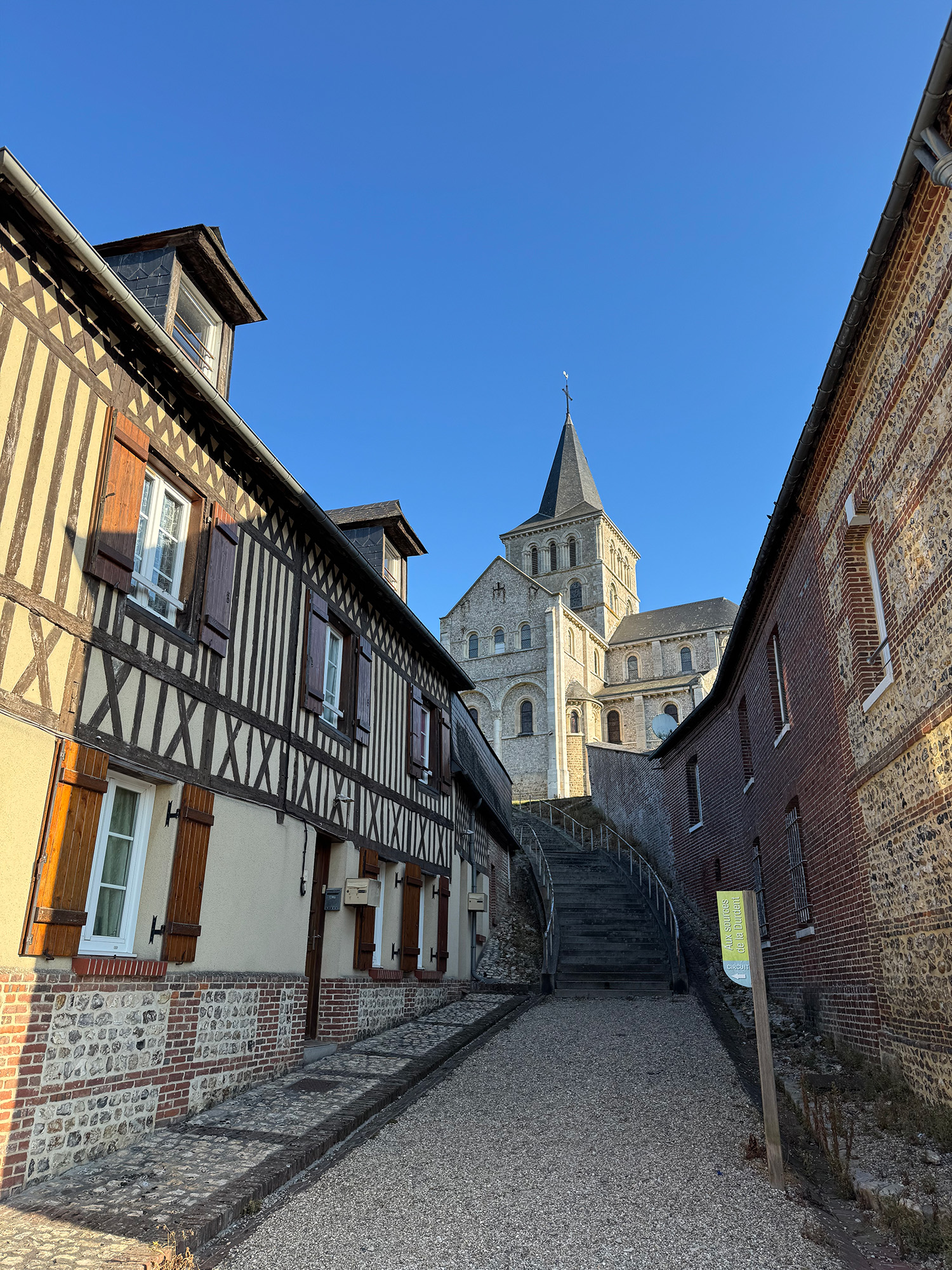 Rue montant vers l’église Saint-Martin à Héricourt-en-Caux, entre colombages, brique et silex