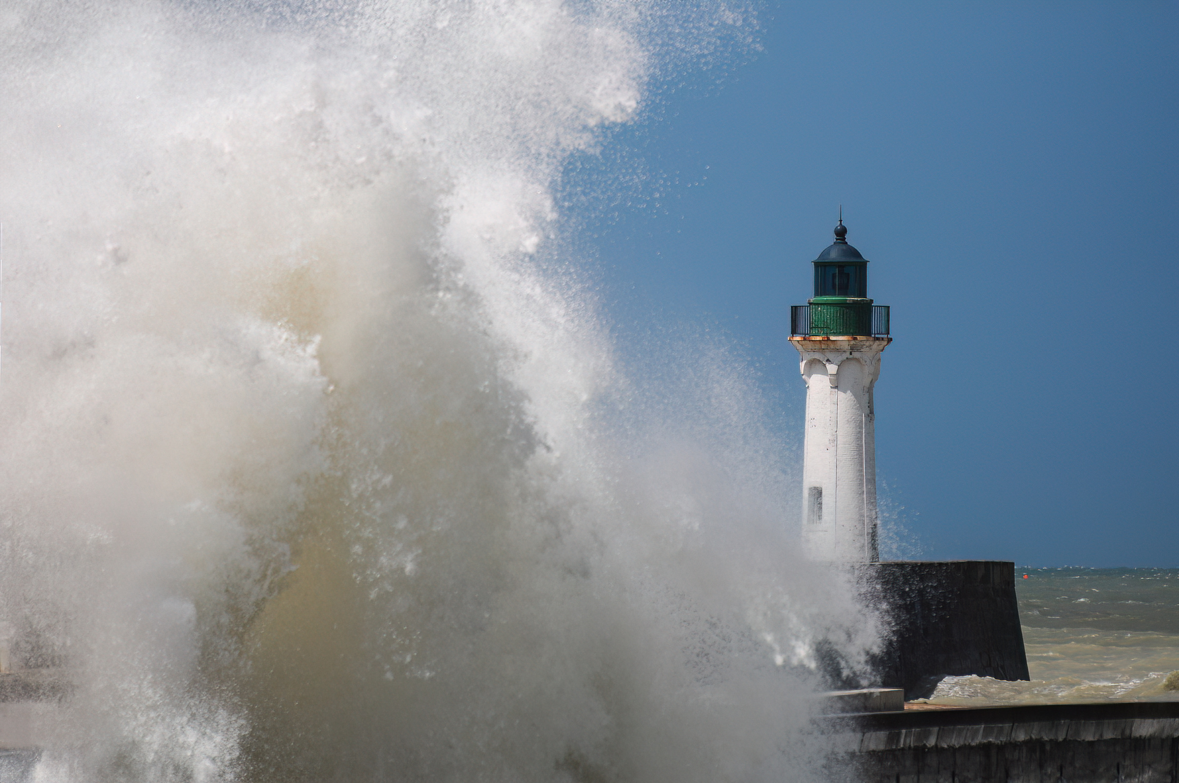 Vague puissante se brisant sur la jetée d’un port de la Côte d’Albâtre