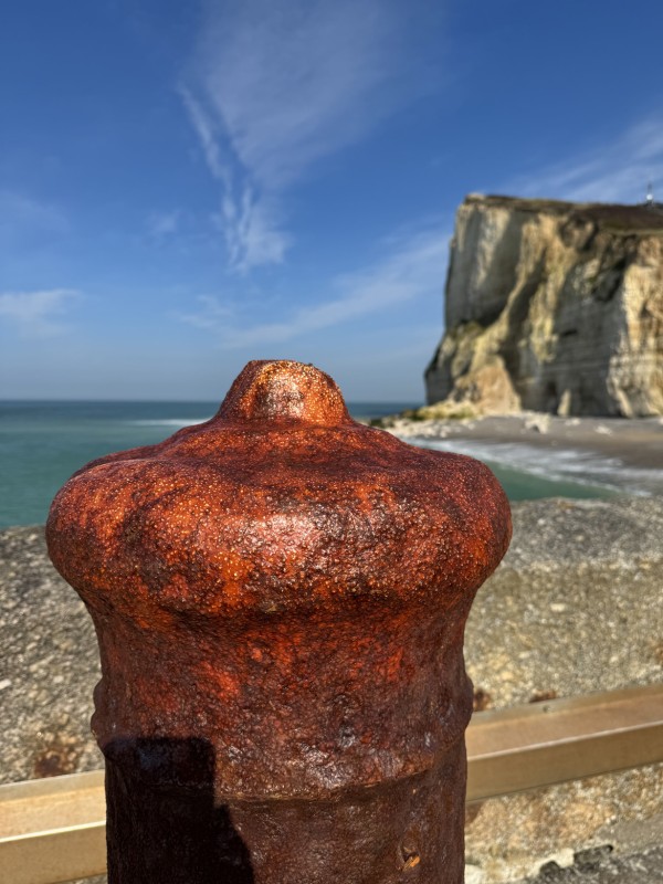 Bitte d'amarrage rouillée face à la mer et aux falaises de Fécamp