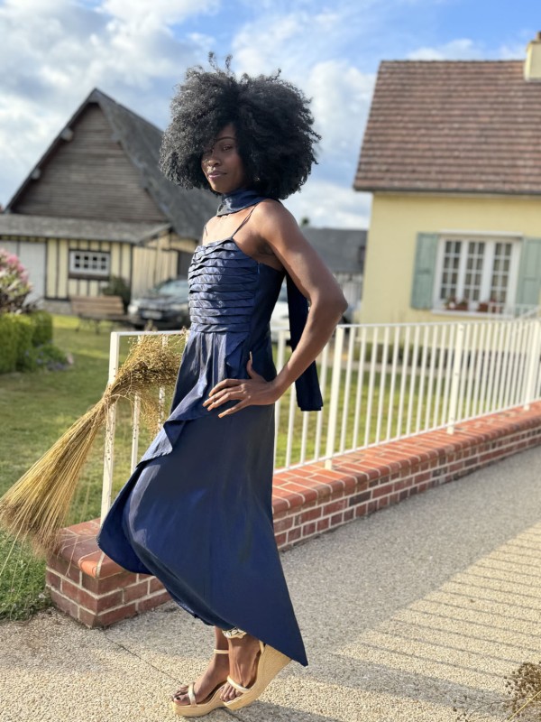 Allure sculpturale et élégance affirmée pour cette création bleu profond, portée avec assurance lors du défilé à Angiens. Les lignes fluides et la texture du lin dialoguent avec la lumière, offrant une silhouette à la fois contemporaine et profondément inspirée par le territoire normand. - Défilé de mode à Angiens - 6 juillet 2025 dans le cadre du festival du lin