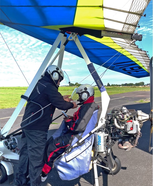Préparatifs de vol ULM à l’aérodrome de Dieppe-Saint-Aubin, casque et briefing avant baptême en ULM"

