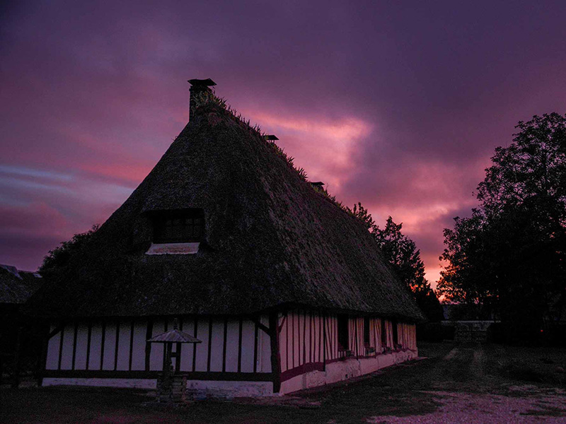 Chaumière normande sous le ciel du soir